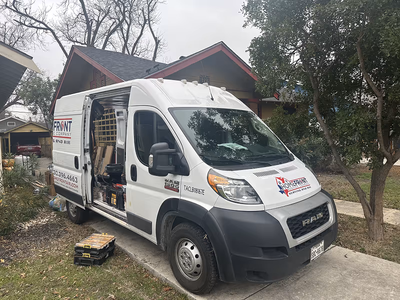 White service van with open side door parked on residential street