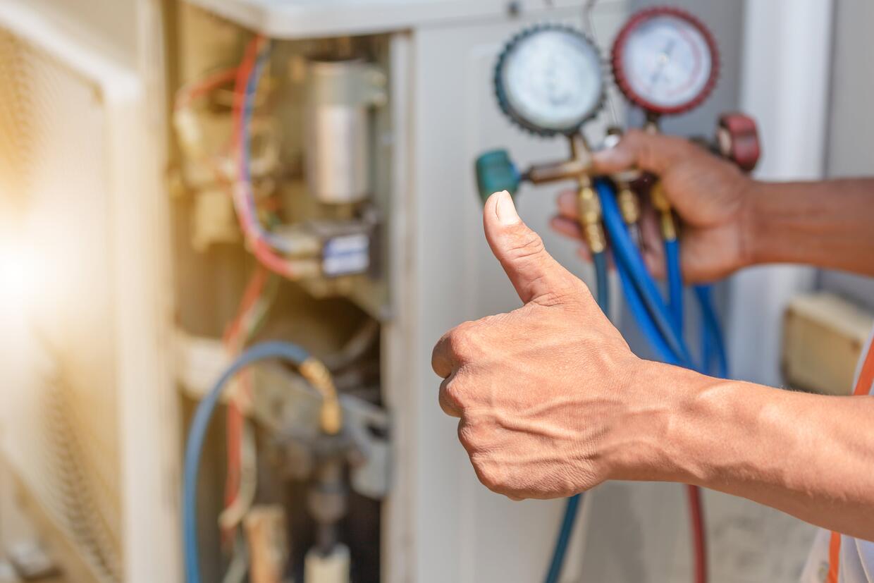 CLOSE UP OF AIR CONDITIONING REPAIR, REPAIRMAN ON THE FLOOR FIXING
