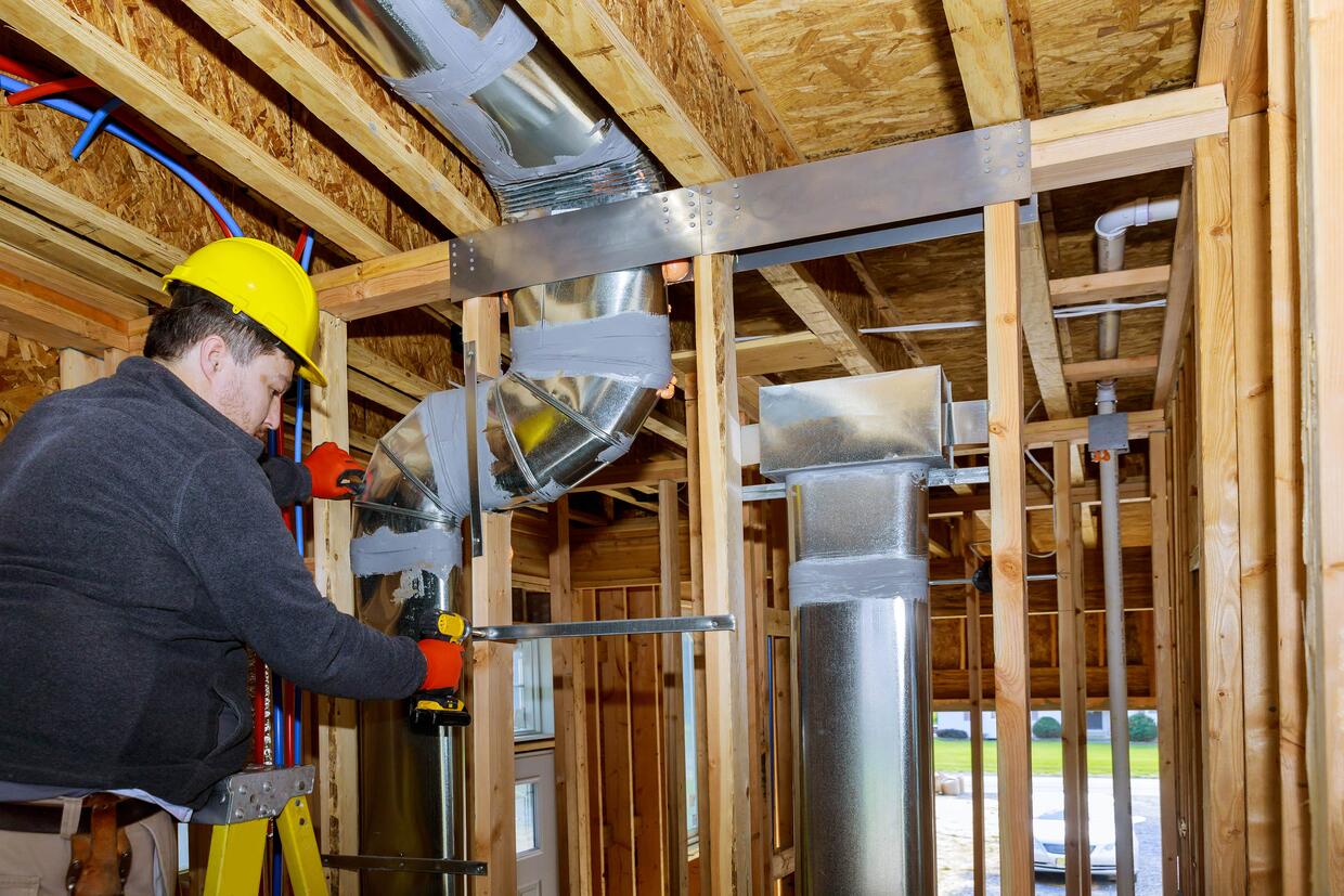 HVAC DUCT VENTILATION PIPES IN SILVER INSULATION OF CENTRAL CONDITIONING A WALL